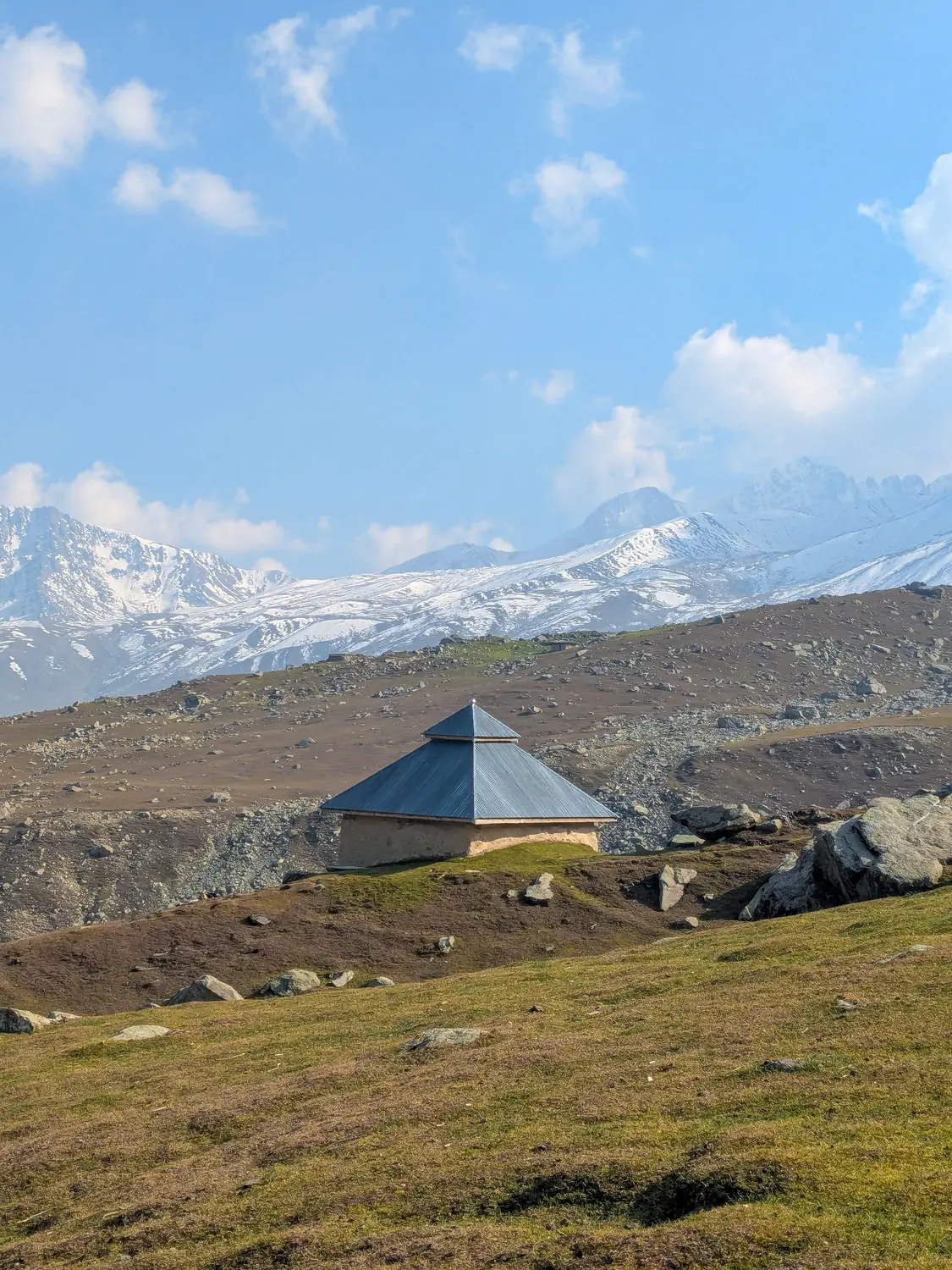Lone tent camp on green alpine meadow with snow capped mountains Gilgit-Baltistan Pakistan