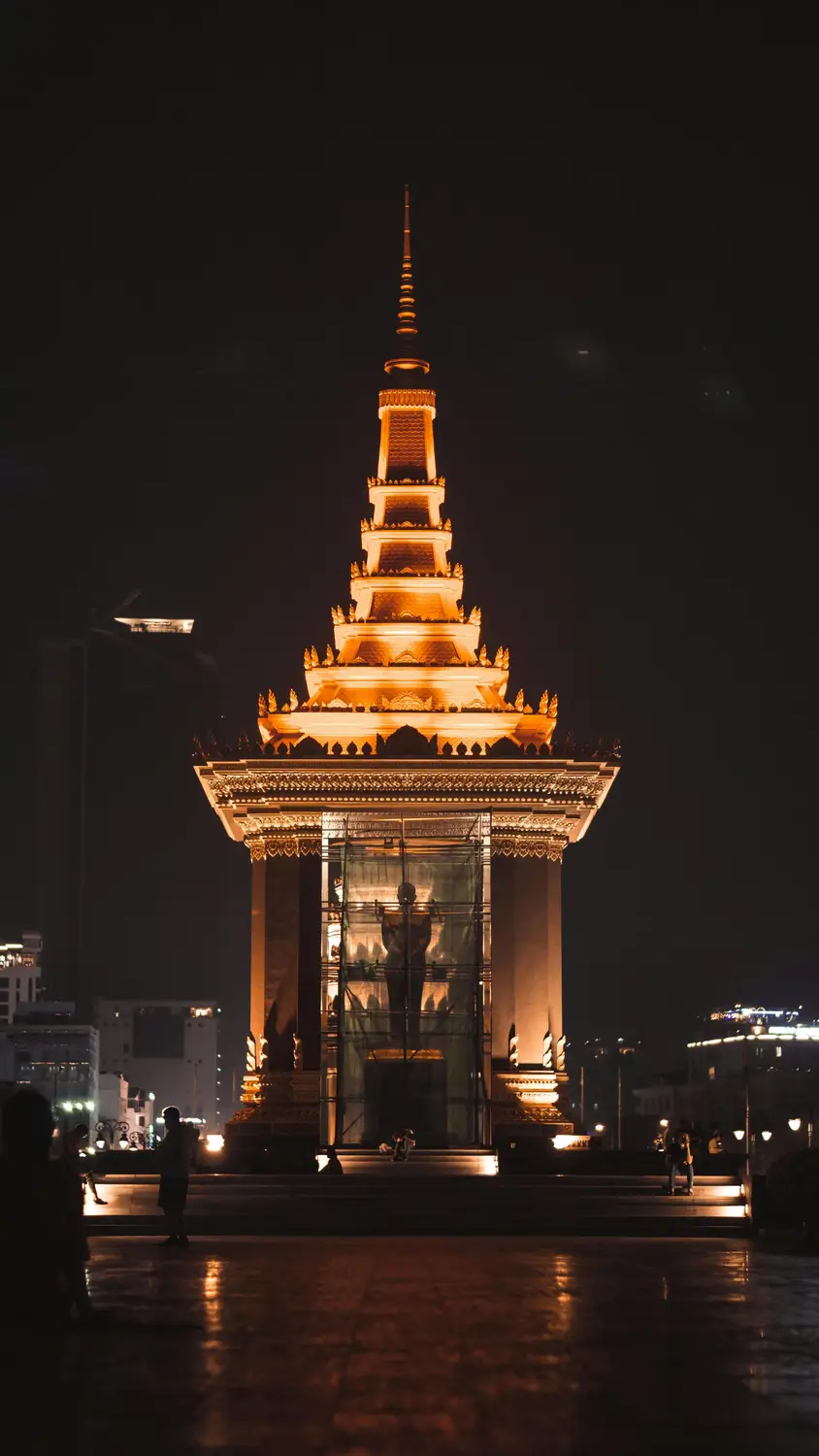 Independence Monument illuminated with golden lights at night, landmark stupa tower in Phnom Penh, Cambodia