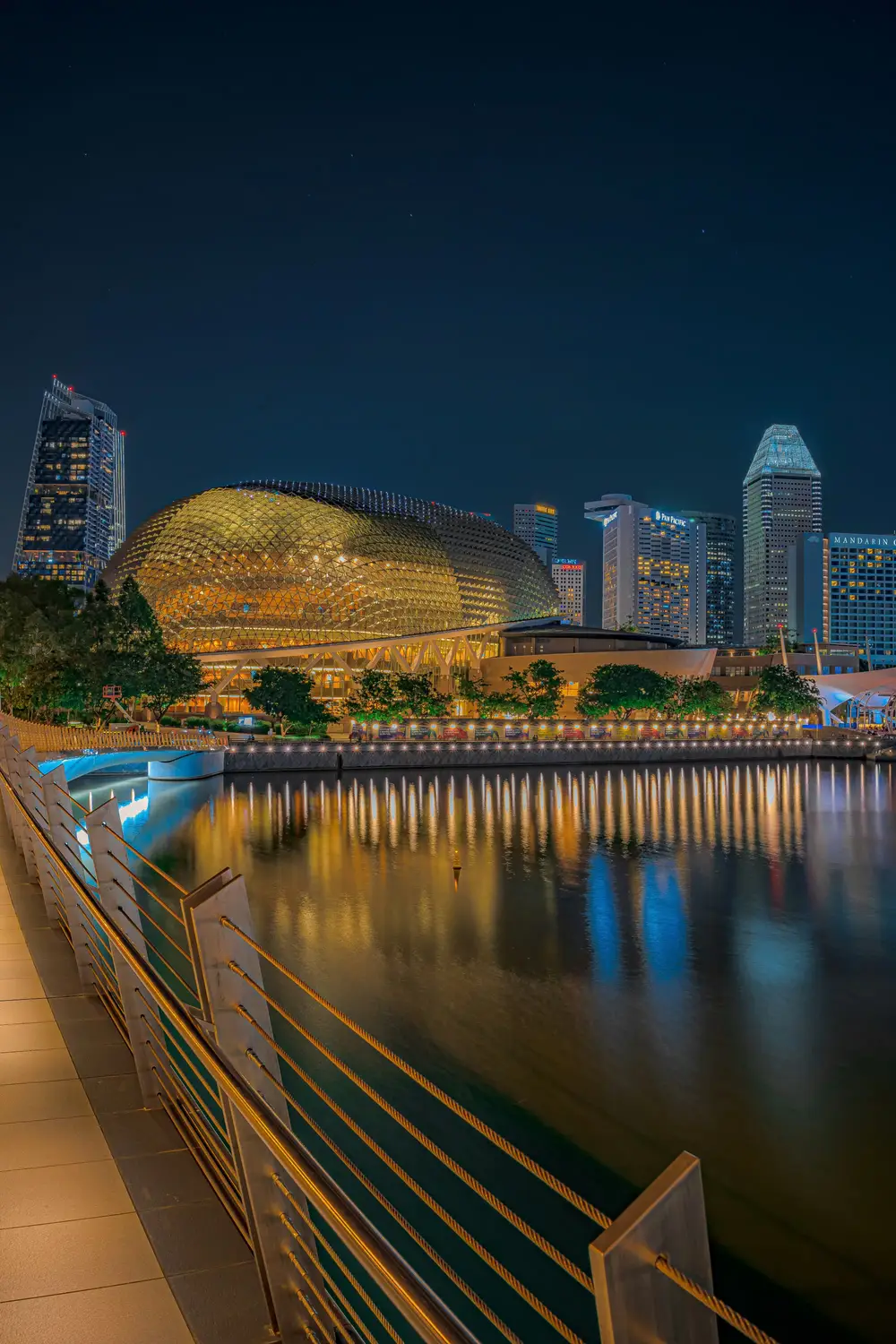 Singapore River waterfront at night with Esplanade theatre and city skyline light reflections