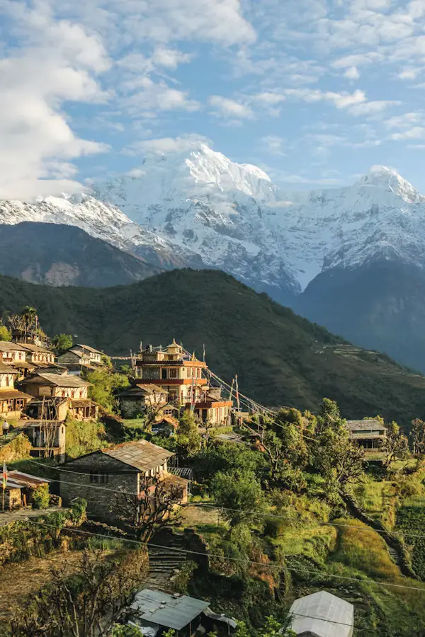 Traditional hillside village with terraced fields below snow-capped Annapurna peaks, NepalTraditional hillside village with terraced fields below snow-capped Annapurna peaks, Nepal