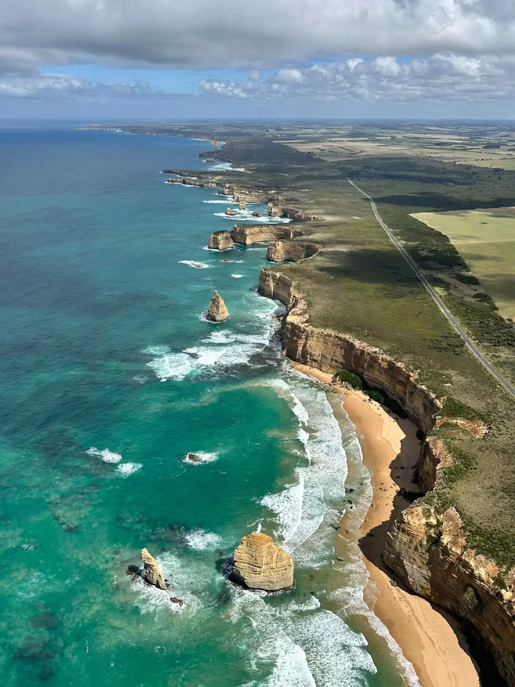 Aerial view of limestone sea stacks and cliffs along the Great Ocean Road coastline, Victoria, Australia