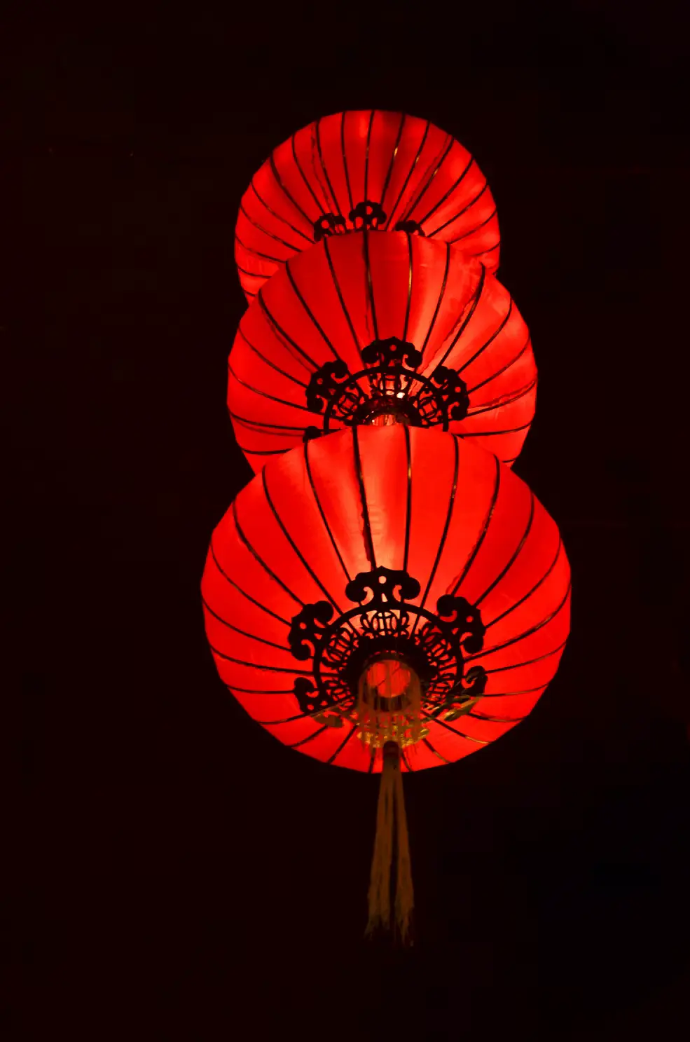 Traditional red Chinese lanterns glowing against a dark background in Hong Kong.
