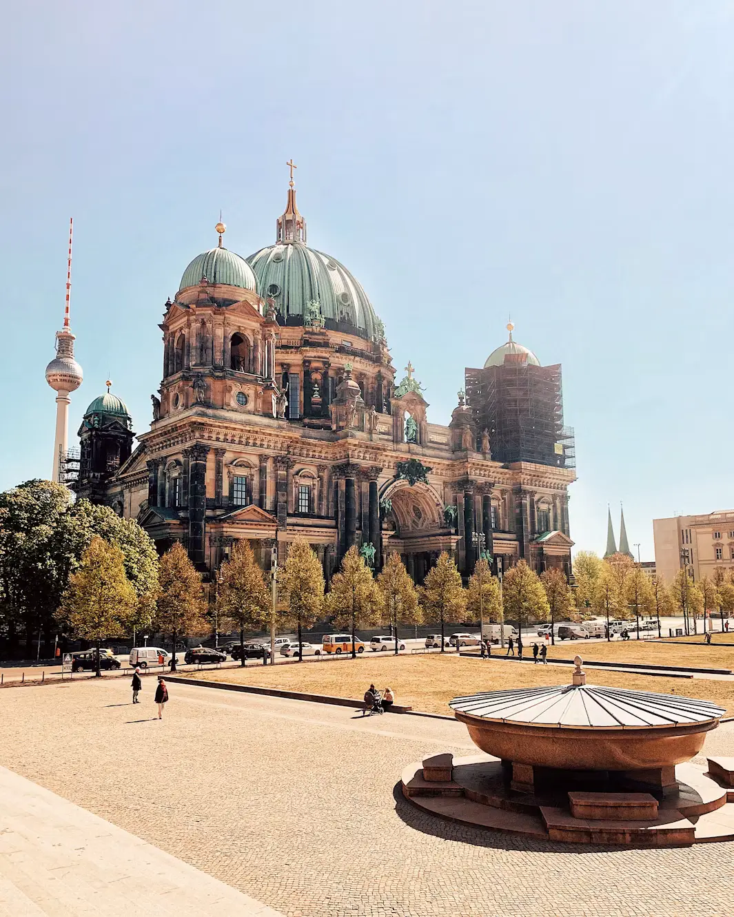Berlin Cathedral seen from the Lustgarten plaza with visitors relaxing outside