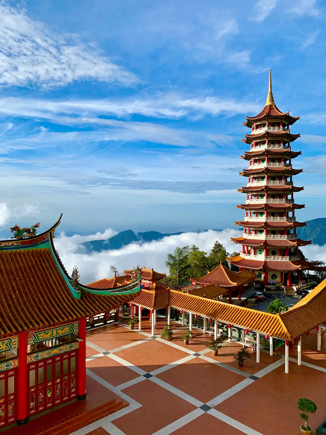 Chin Swee Caves Temple red pagoda tower with traditional Chinese architecture surrounded by clouds and mountains in Genting Highlands Malaysia
