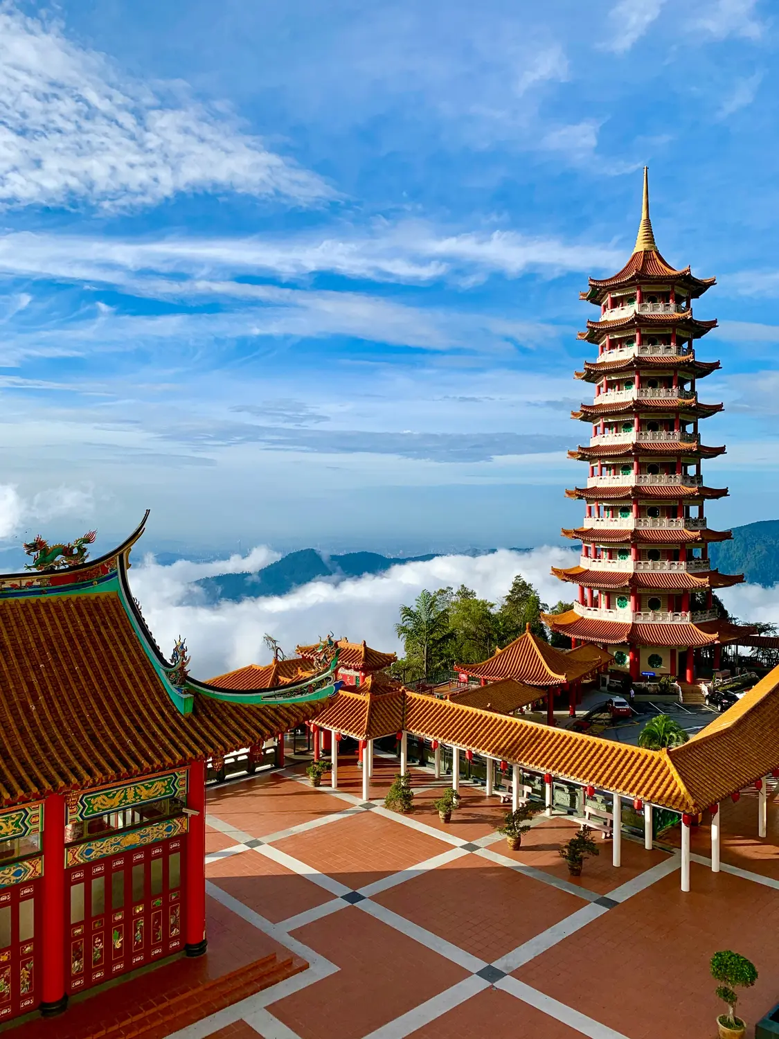 Chin Swee Caves Temple red pagoda tower with traditional Chinese architecture surrounded by clouds and mountains in Genting Highlands Malaysia