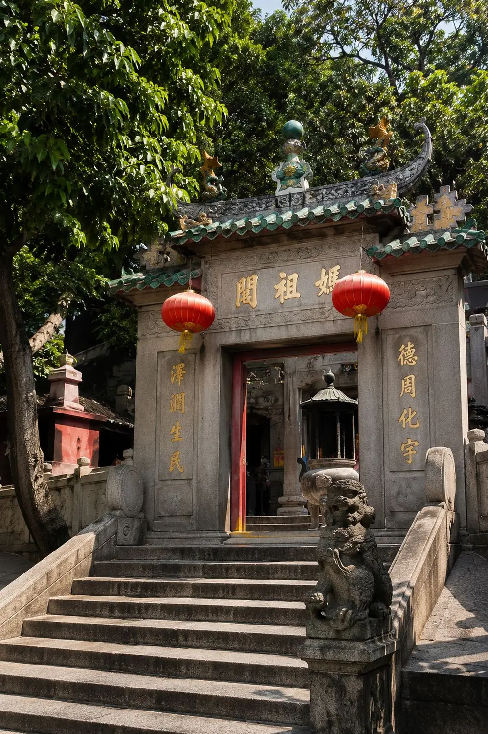 Chinese temple gate with red lanterns and stone lion statues on staircase