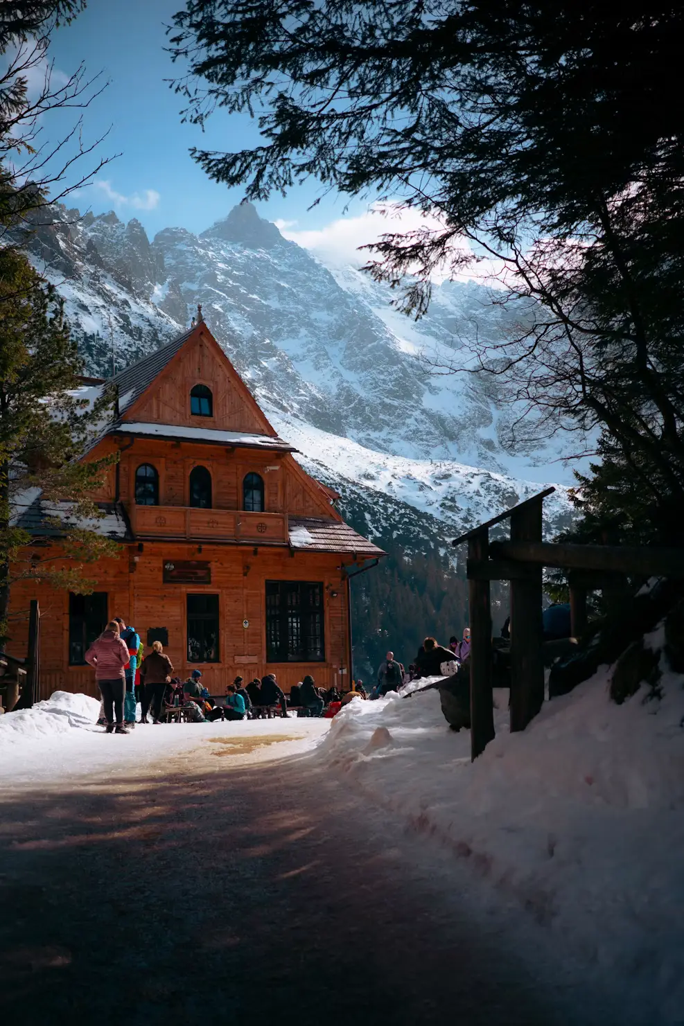 Red mountain chalet dusted with snow, set against a dramatic peak, Poland.