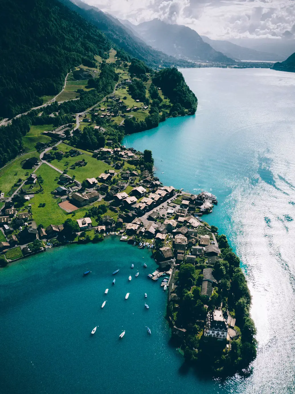 Aerial view of a lakeside village with boats and mountains, Switzerland