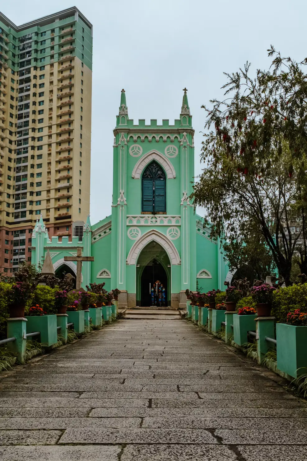 Mint-green St. Lazarus Church at the end of a stone pathway, Macau