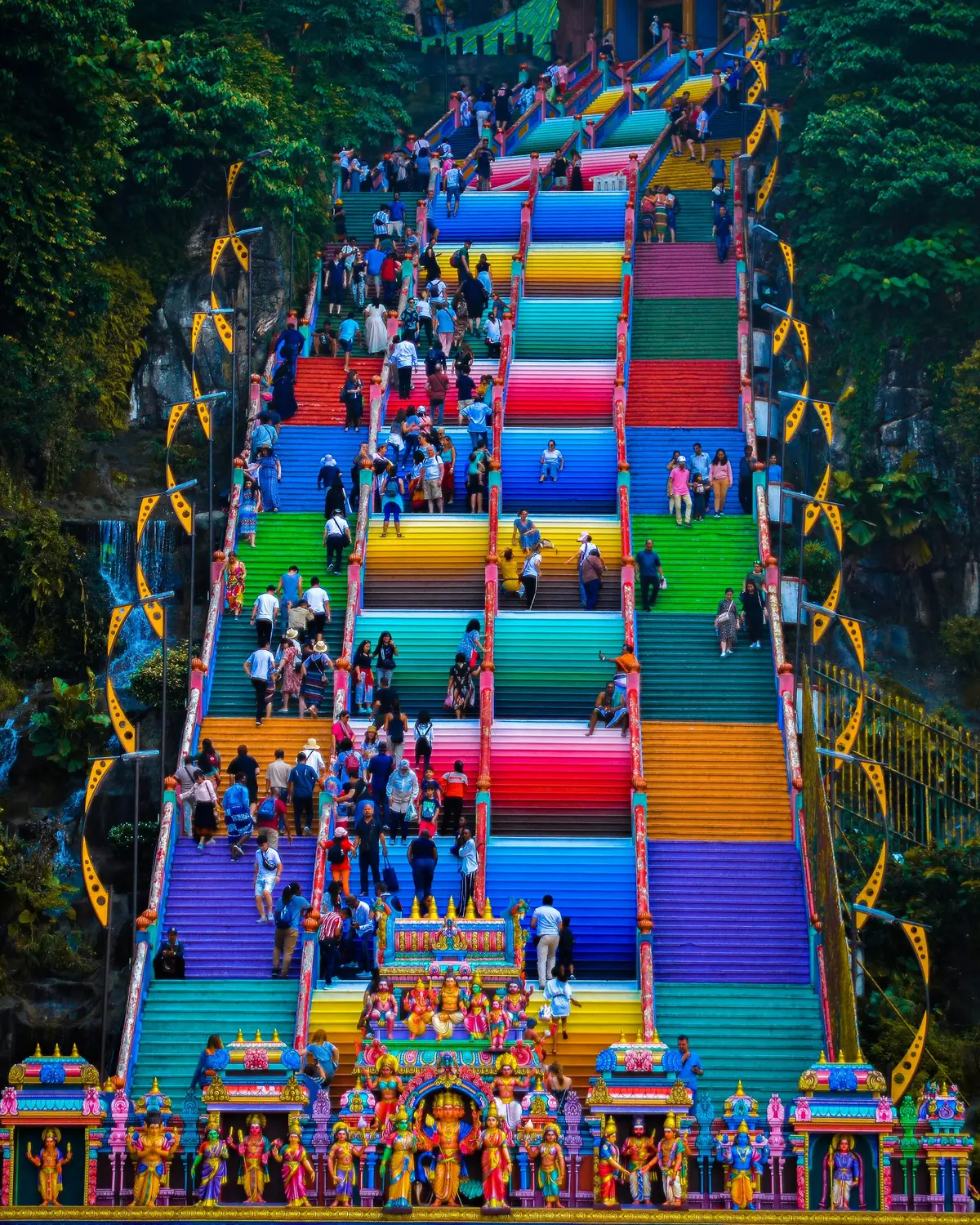 Colorful rainbow painted steps of Batu Caves temple with crowds of visitors climbing in Kuala Lumpur Malaysia