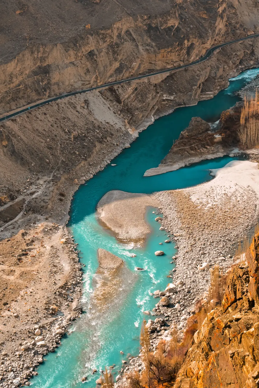 Aerial view of turquoise Indus River winding through rocky desert canyon Gilgit-Baltistan Pakistan