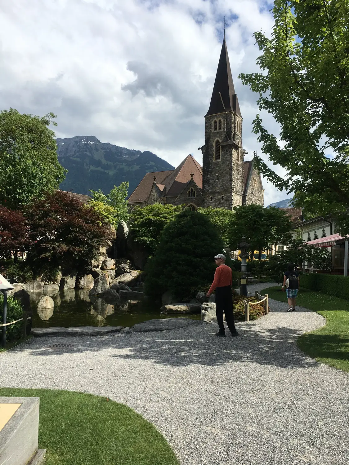 Church steeple and courtyard with mountains in the background, Switzerland