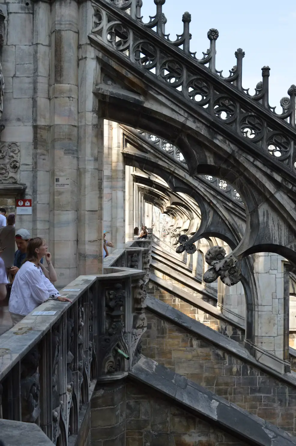 Visitor exploring the Gothic spires and rooftop terraces of Milan Cathedral