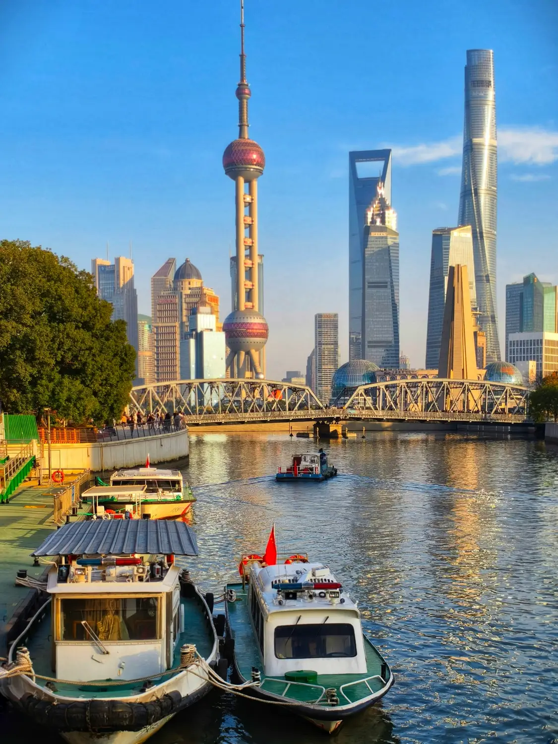 Shanghai Pudong skyline with Oriental Pearl Tower Shanghai Tower and Waibaidu Bridge over Suzhou Creek at golden hour