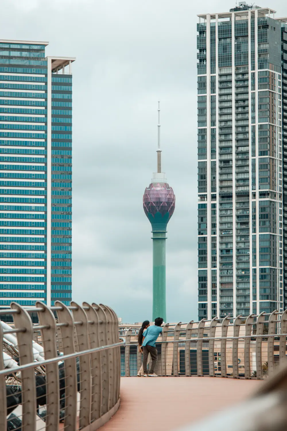 Lotus Tower rising between modern glass skyscrapers in the Colombo city skyline, Sri Lanka.