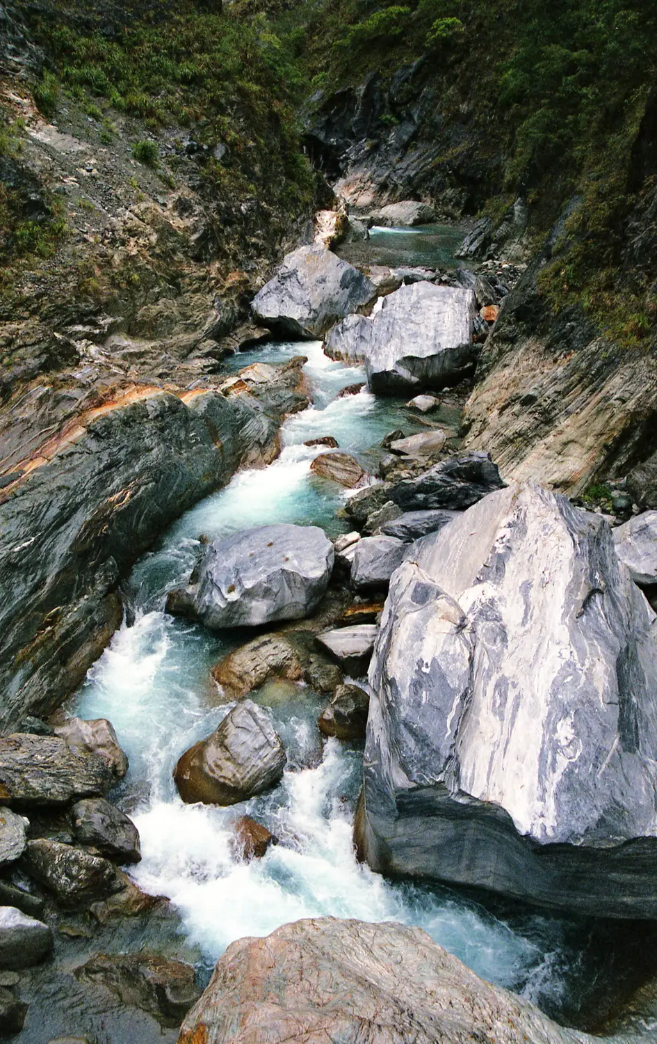 Turquoise river rushing over marble boulders through the rocky gorge of Taroko National Park in Taiwan
