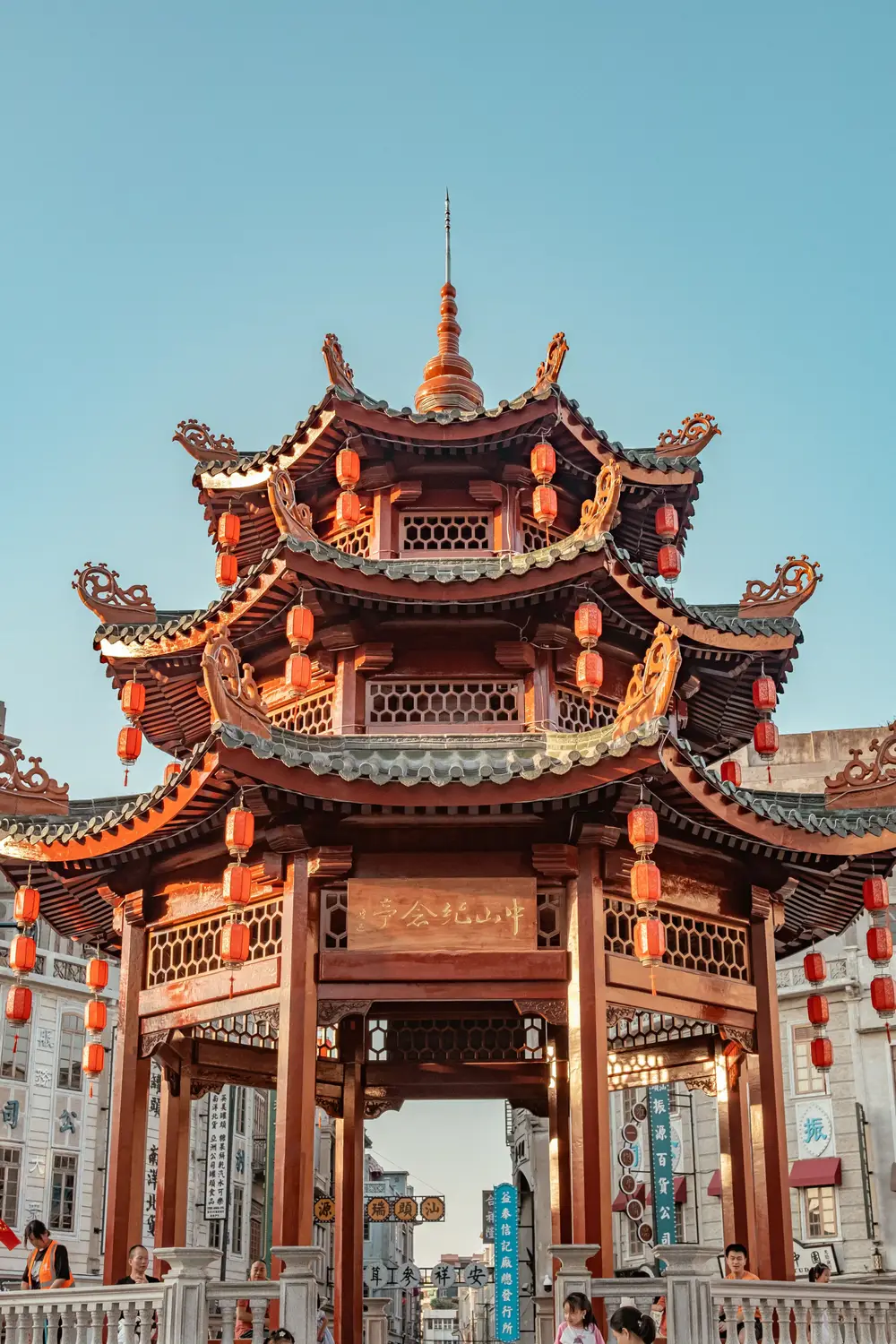 Multi-tiered traditional Chinese wooden pagoda pavilion decorated with red lanterns at sunset in Shantou Guangdong