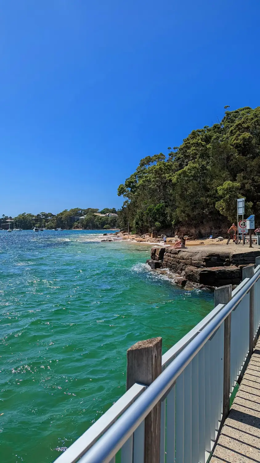 Coastal boardwalk beside turquoise ocean water on a sunny day, Australia