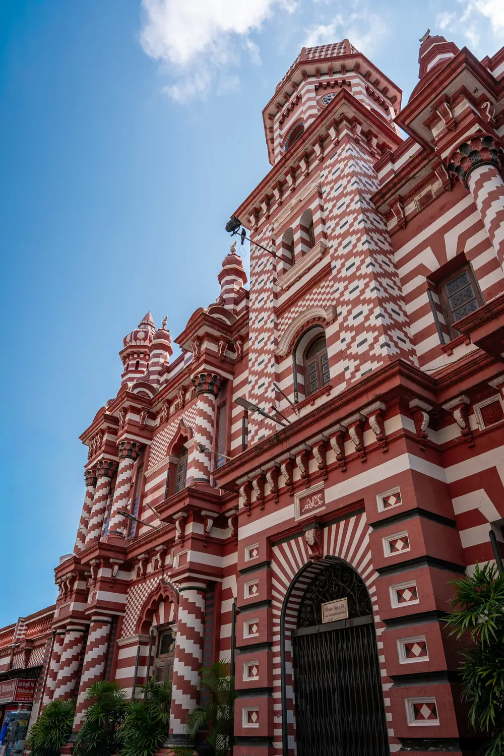 Striking red and white striped Jami Ul-Alfar Mosque with ornate architecture against a blue sky in Colombo, Sri Lanka.