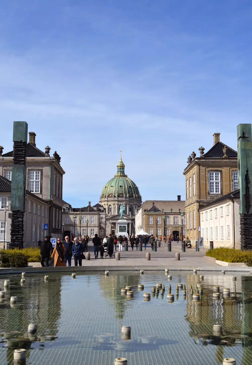 Amalienborg Palace square in Copenhagen with Frederik's Church dome visible and a reflecting pool in the foreground