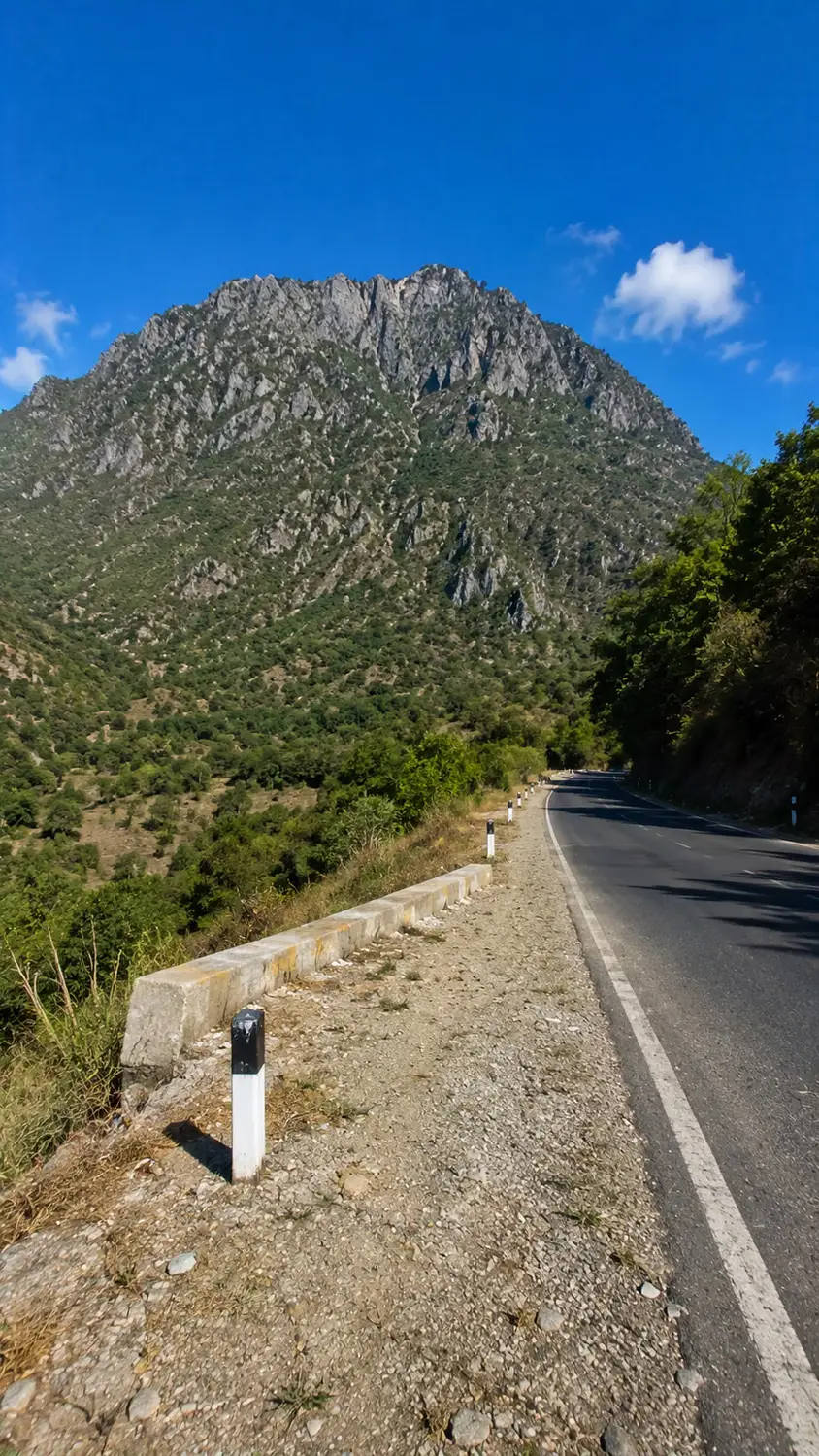 Mountain road with rocky peaks under clear blue sky Timor-Leste