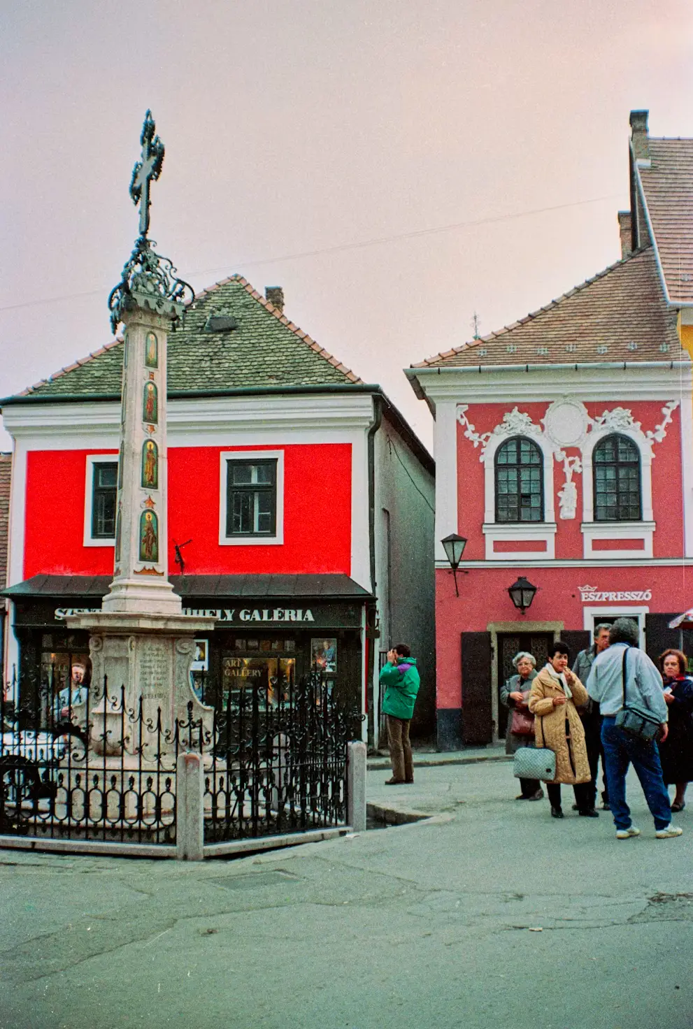 Baroque square with a decorated plague column and colorful historic buildings.