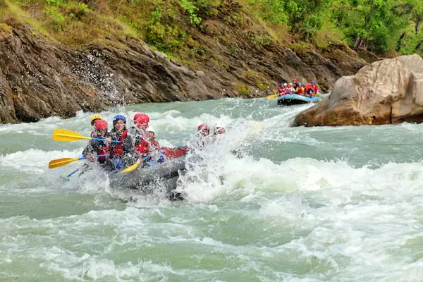 Group white water rafting through churning rapids on a mountain river, Nepal