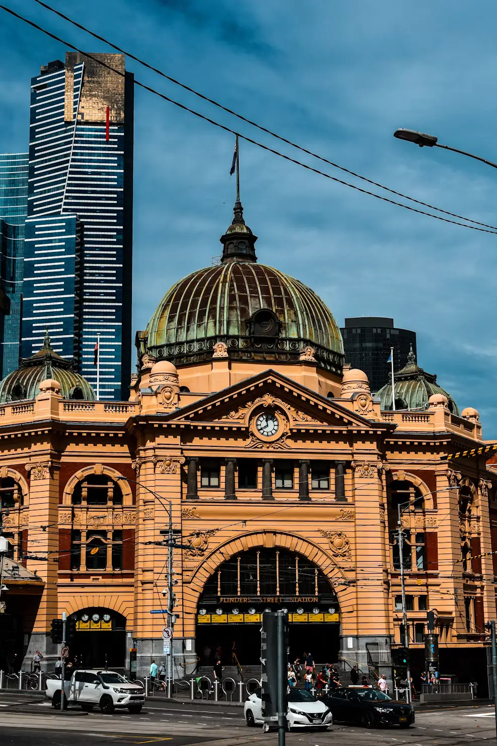 Flinders Street Station's historic facade with city skyscrapers behind, Melbourne, Australia