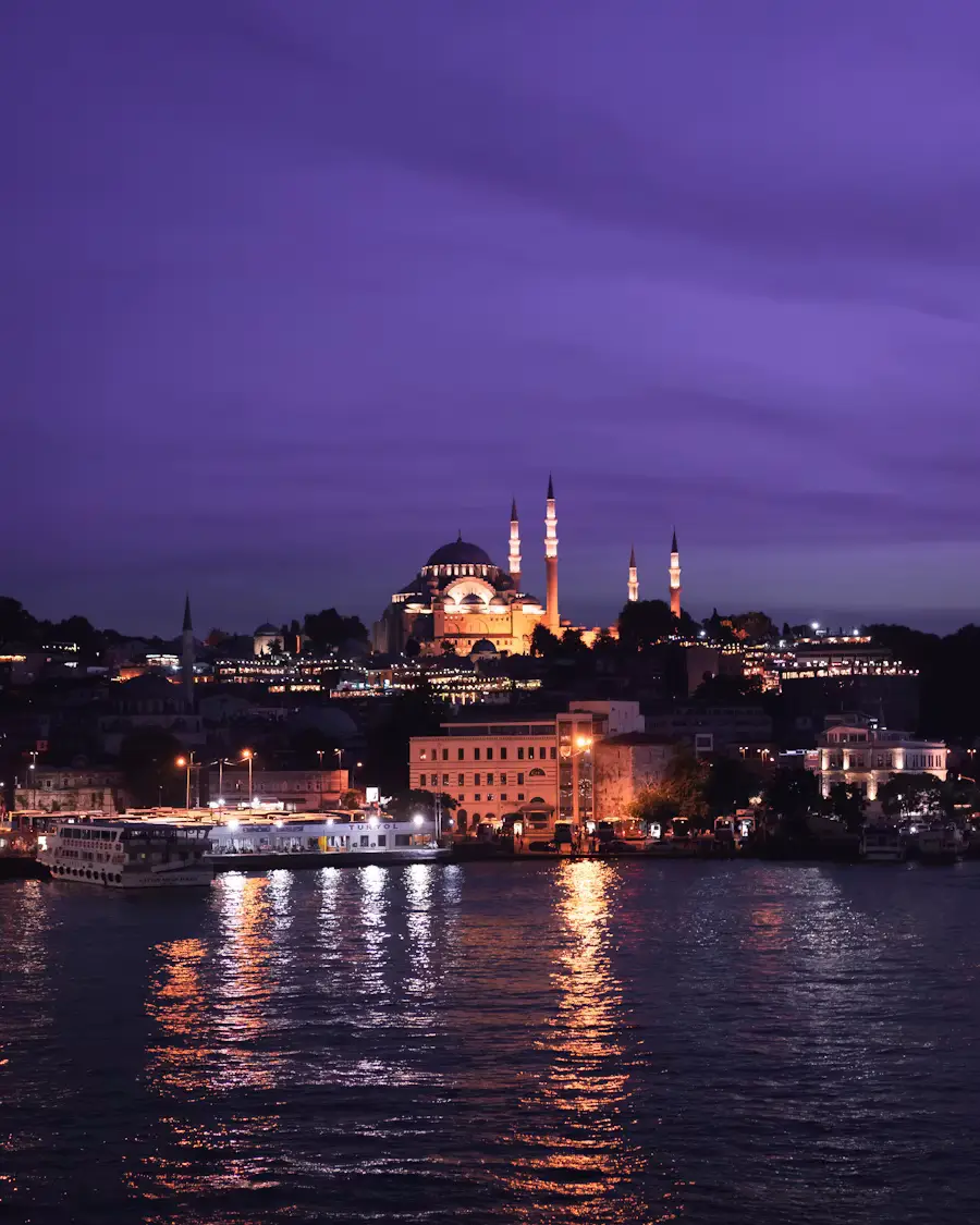 A dusk view of Istanbul's skyline with illuminated domes and minarets reflected in the calm waters of the Bosphorus.