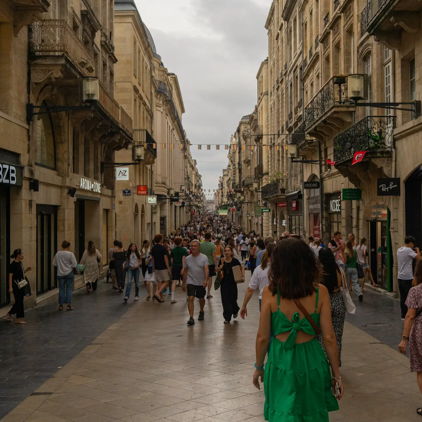 Woman walking down a busy pedestrian shopping street in Bordeaux, France
