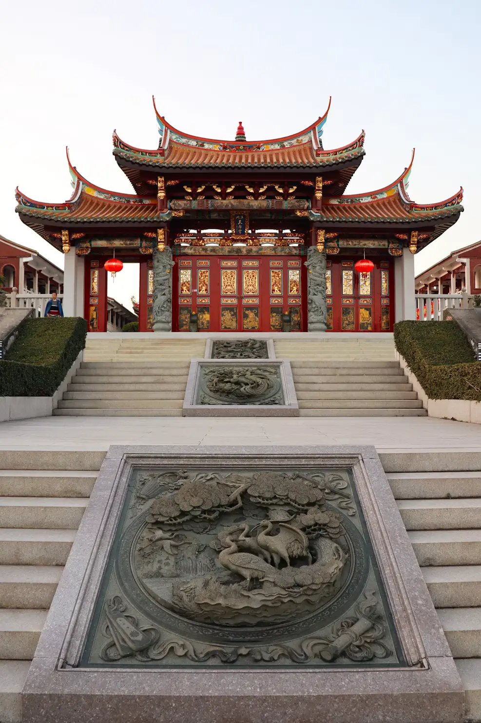 Close-up of ornate golden Chinese dragon and phoenix carving on temple roof ridge.