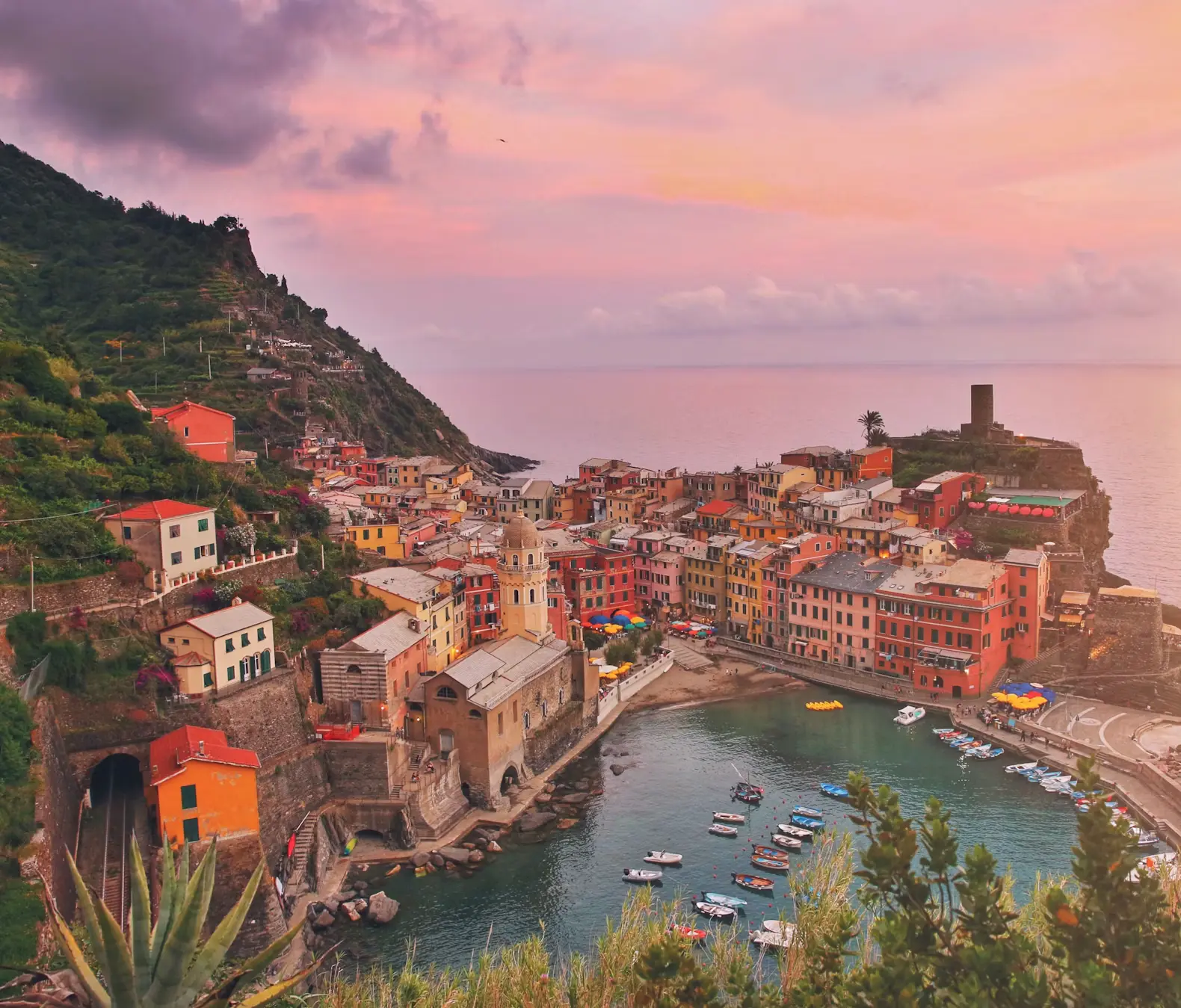 Aerial view of Vernazza harbor at sunset with colorful cliffside buildings, Cinque Terre, Italy