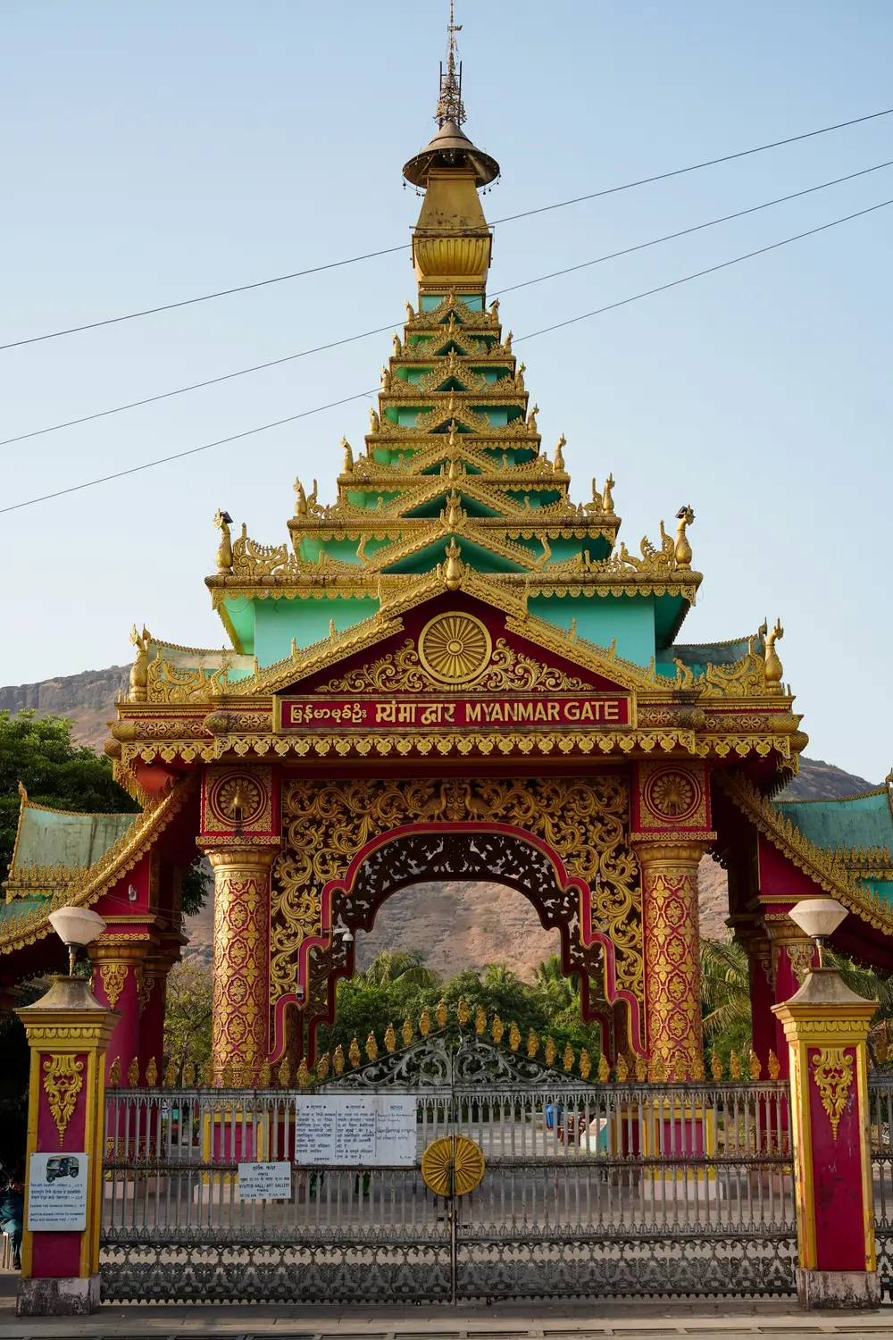 Ornate Myanmar Gate with tiered golden and green pagoda-style architecture and Hindi signage, Buddhist pilgrimage site India