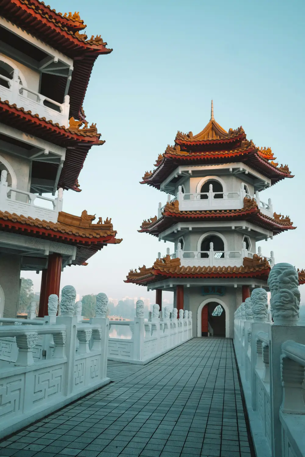 Twin Pagodas at Chinese Garden Singapore with white marble bridge balustrades and stone lion sculptures at dusk