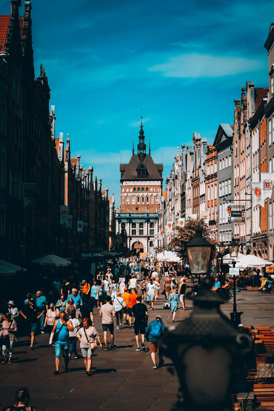 Bustling historic European street lined with colorful buildings and filled with pedestrians.