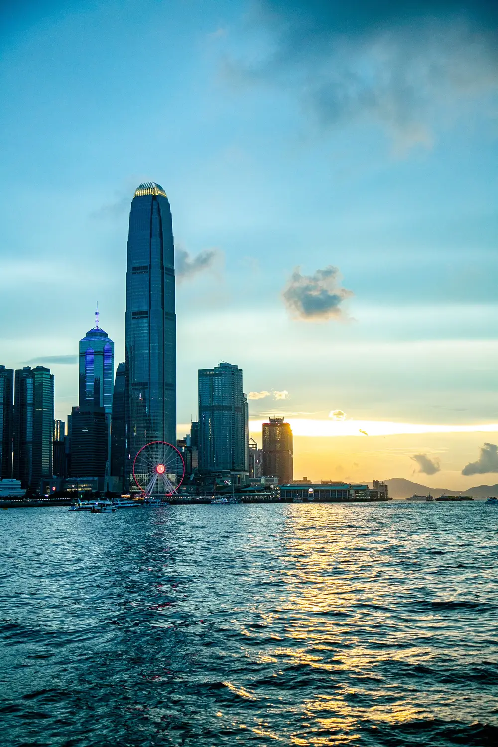 Hong Kong Island skyline at dusk with skyscrapers reflected in Victoria Harbour in Hong Kong.