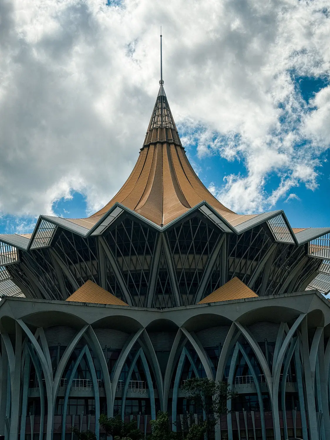 Low angle view of Putra International Convention Centre distinctive pointed petal-shaped roof architecture against cloudy sky in Putrajaya Malaysia
