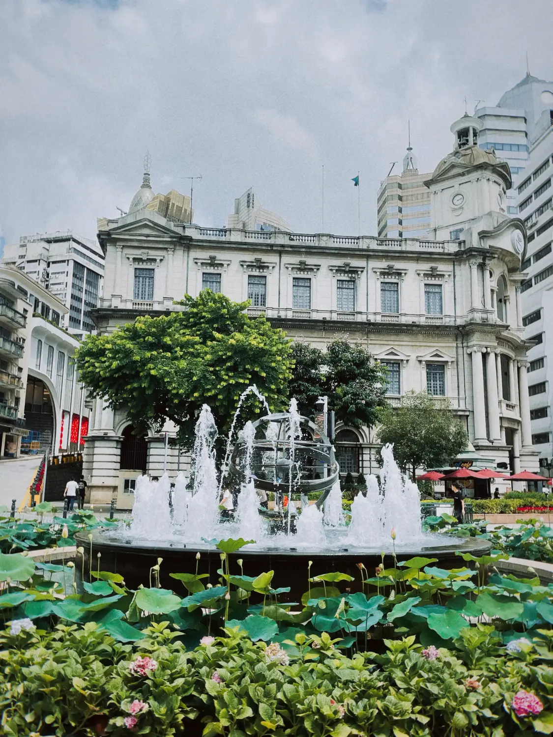 White colonial building facade with garden fountain and lotus pond, Macau