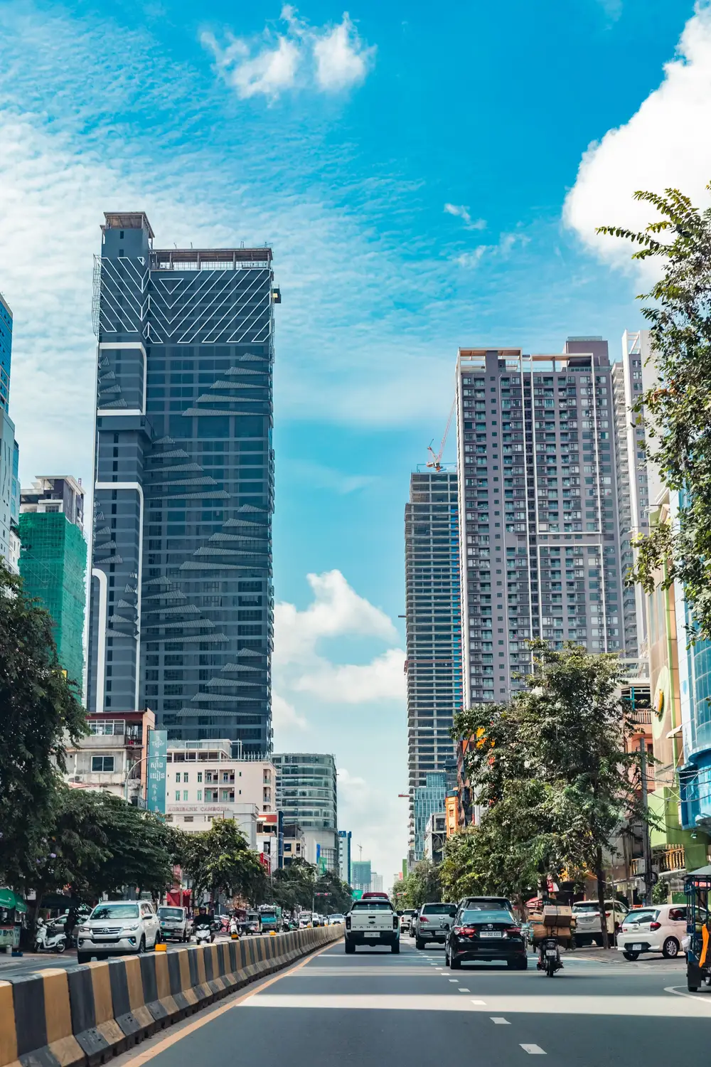 Modern skyscrapers and high-rise buildings under construction lining busy city boulevard in Phnom Penh, Cambodia