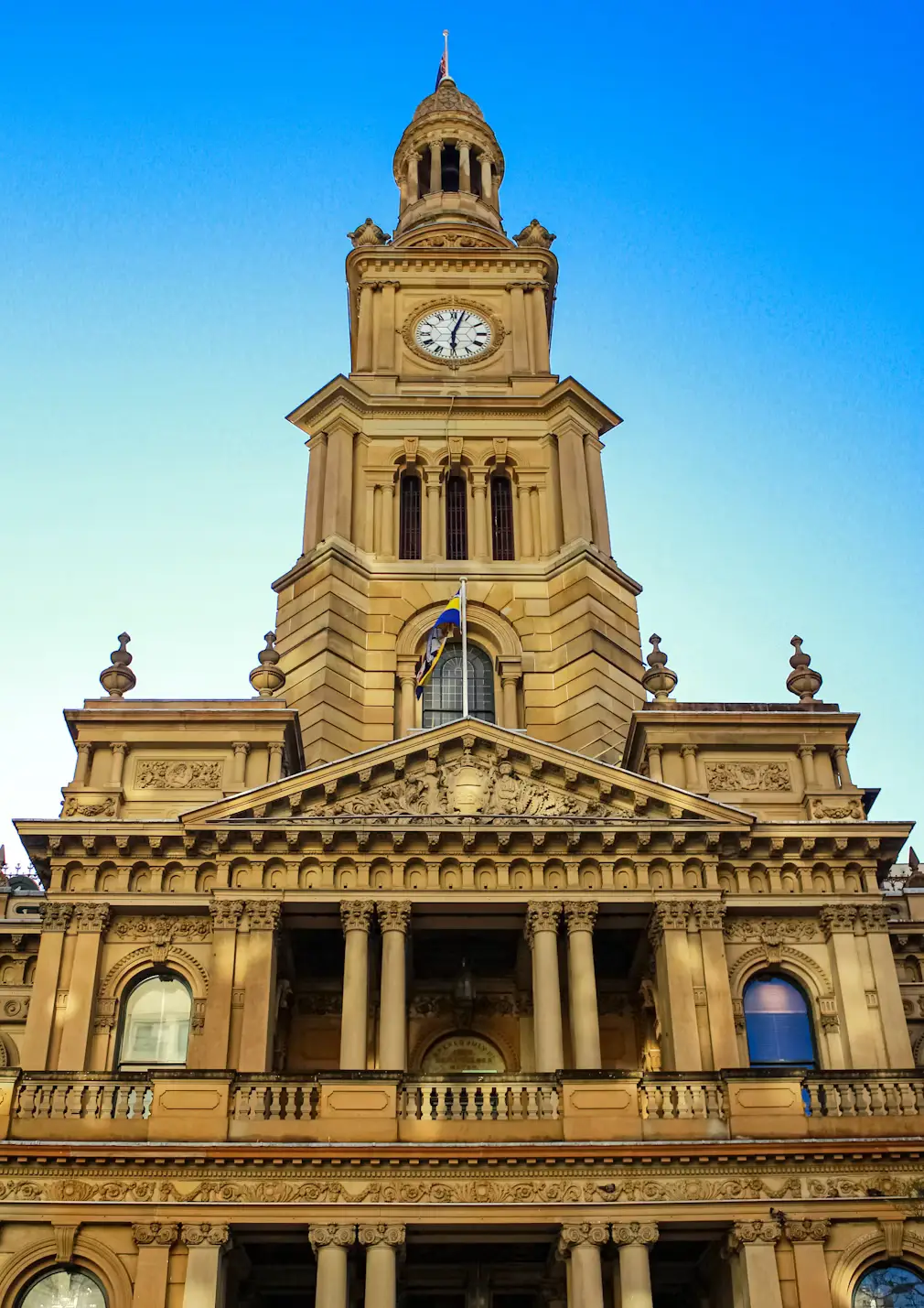 Historic sandstone clock tower building against a blue sky, Sydney, Australia