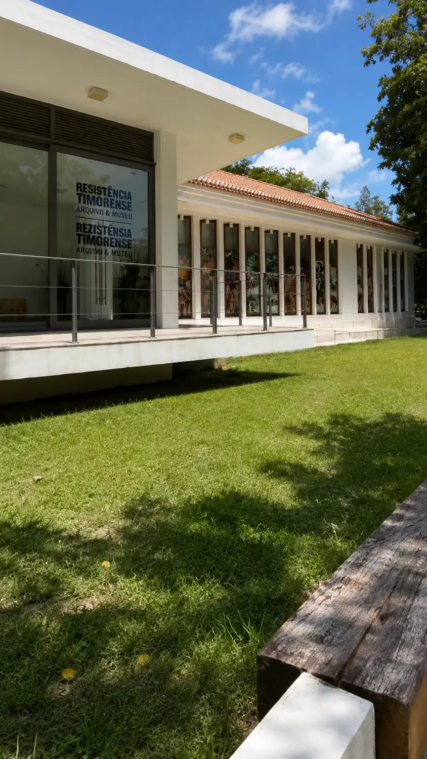Resistência Timorense Archive and Museum (Arquivo & Museu da Resistência Timorense) exterior in Dili, East Timor – modern white building with large glass windows displaying murals on a sunny day