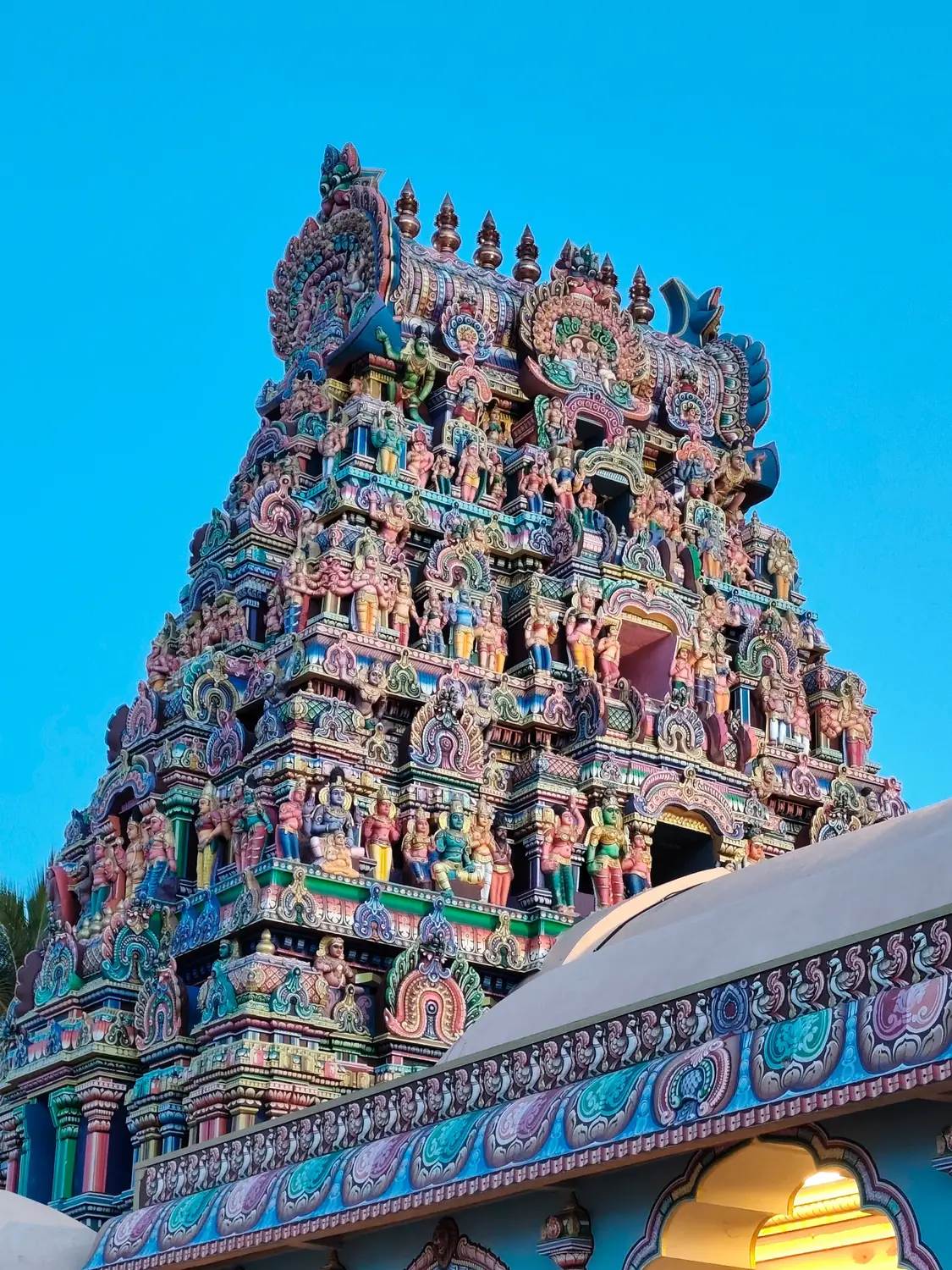 Colorful Dravidian gopuram tower with painted Hindu deity sculptures at South Indian temple, Tamil Nadu