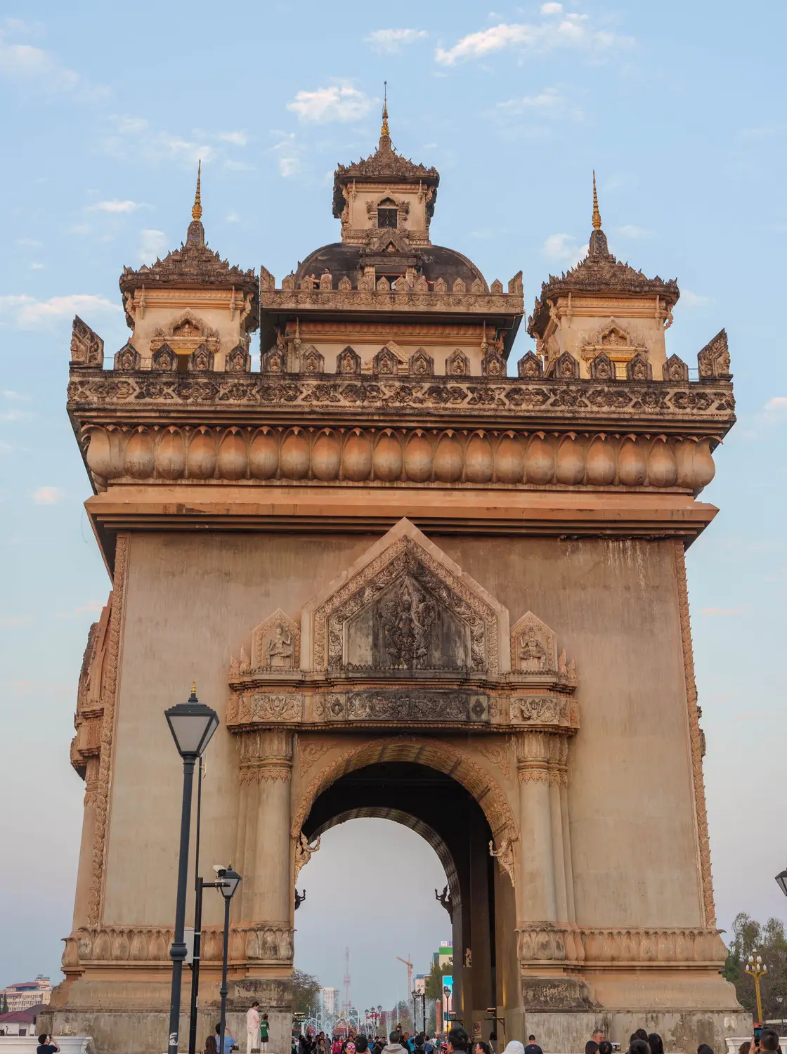 Patuxai victory monument, an ornate arch gateway, under a blue sky in Vientiane, Laos.