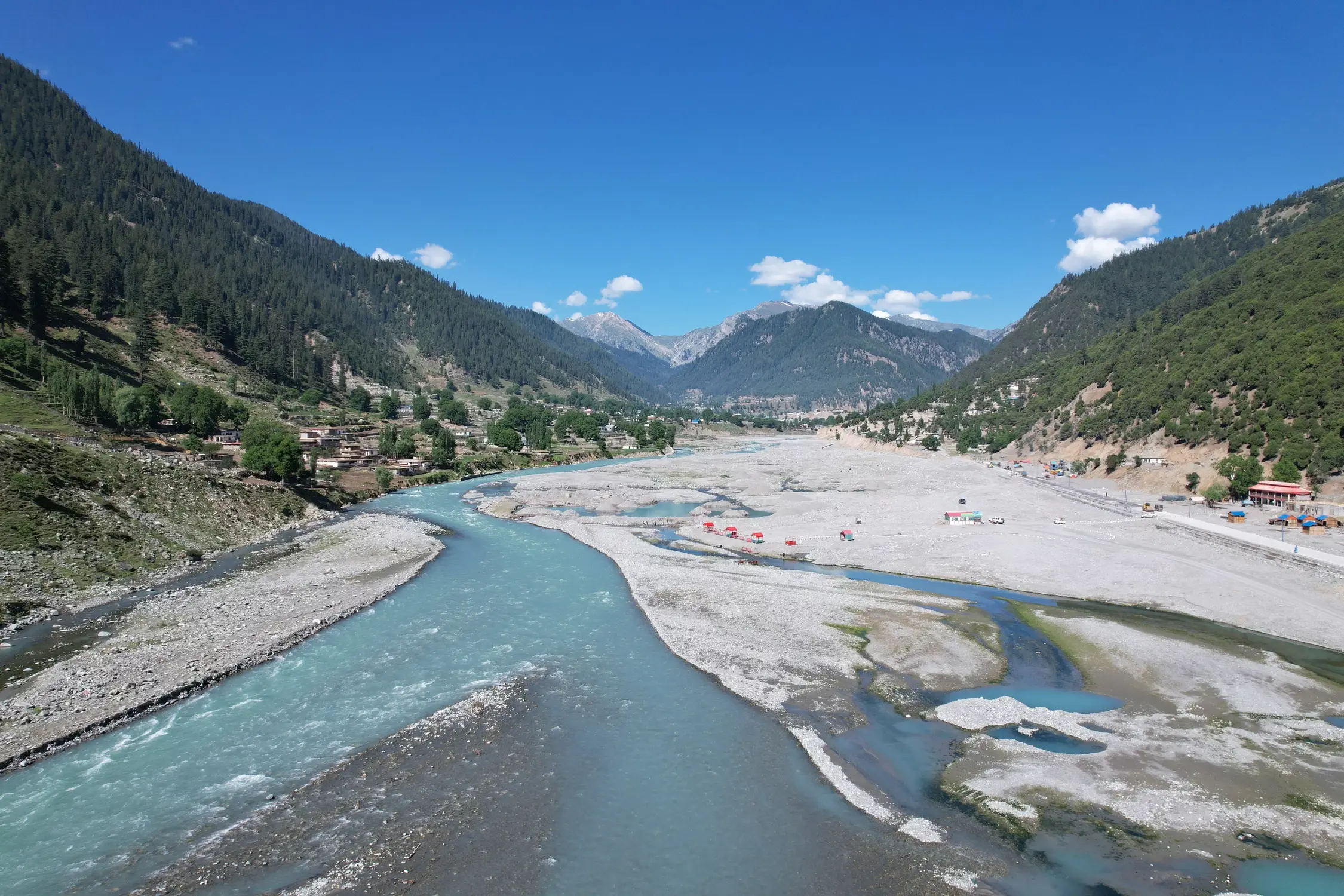 Turquoise Kunhar River flowing through Naran valley surrounded by pine covered mountains Pakistan