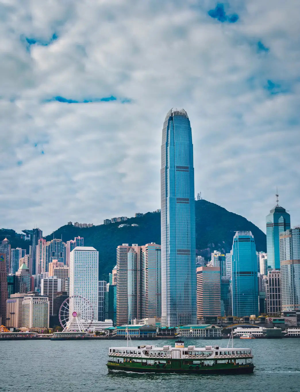 Hong Kong Island skyline with the Two IFC tower rising above Victoria Harbour and a Star Ferry crossing the water in Hong Kong.