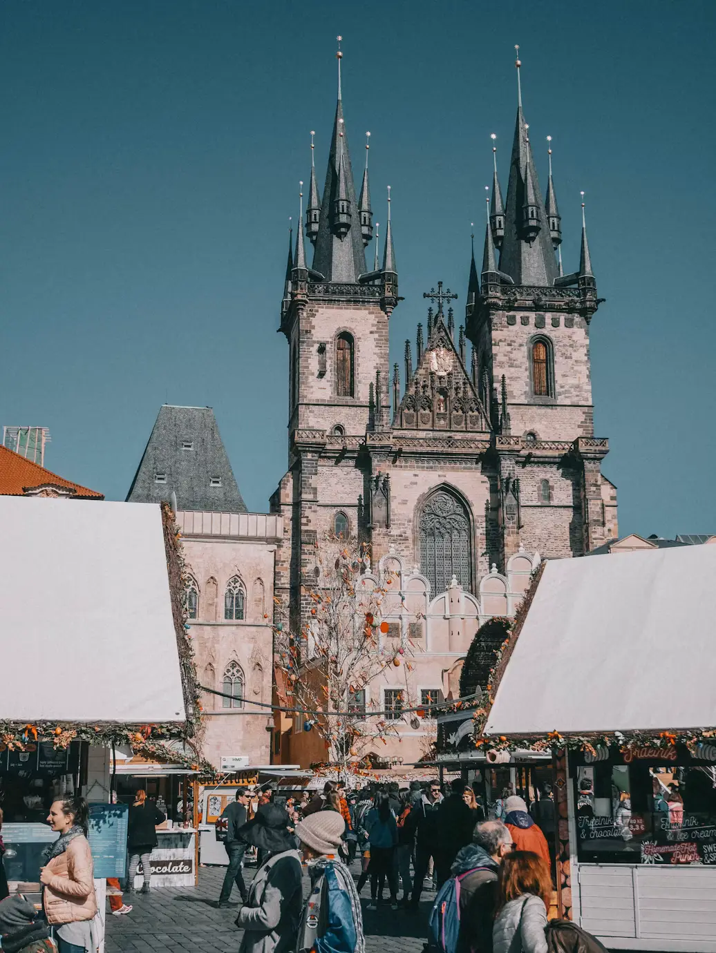 Christmas market stalls in front of Týn Church's twin Gothic spires in Old Town Square