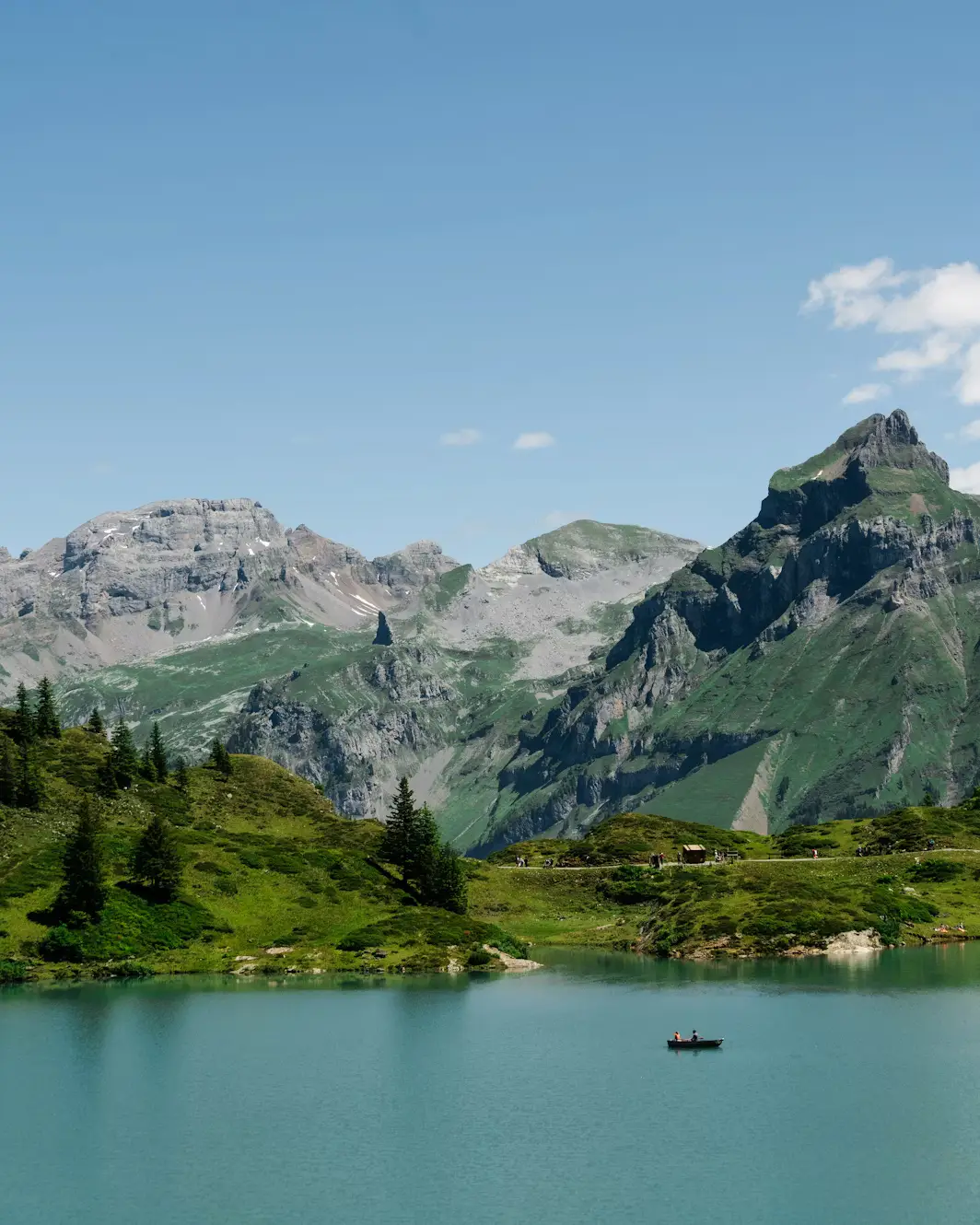 Small boat on a turquoise alpine lake framed by rugged mountain peaks, Switzerland