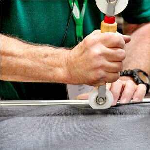 man installing new window screen in metal frame