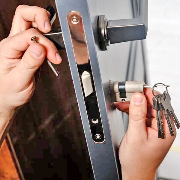 hands holding tools rekeying a front door