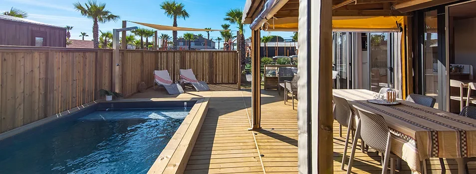 Nouveau mobil-home Oasis Premium & Pool : moderne avec terrasse en bois et piscine privée.